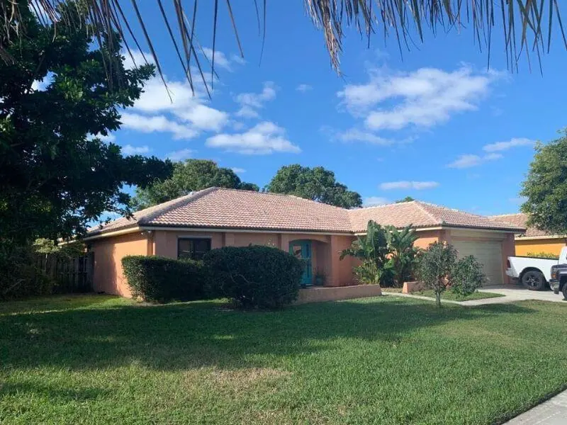 Single-story home with a terracotta concrete tile roof and a green lawn